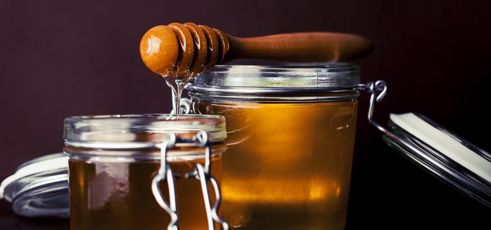 Ahşap bal kaşığı ve içi bal dolu cam kavanozlar