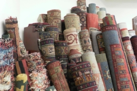 Üst üste dizilmiş, rulo halinde sarılı renkli ve desenli halılar