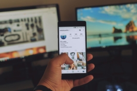 Elinde sosyal medya akışı açık bir akıllı telefon tutan kullanıcı