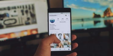 Elinde sosyal medya akışı açık bir akıllı telefon tutan kullanıcı