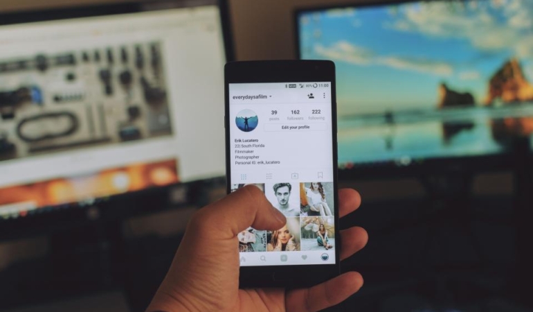 Elinde sosyal medya akışı açık bir akıllı telefon tutan kullanıcı