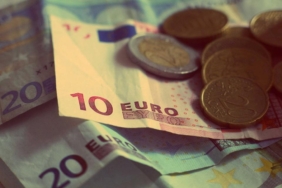 Üst üste duran euro banknotları ve üzerlerindeki madeni paralar