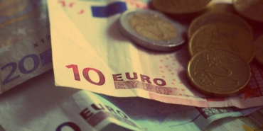 Üst üste duran euro banknotları ve üzerlerindeki madeni paralar