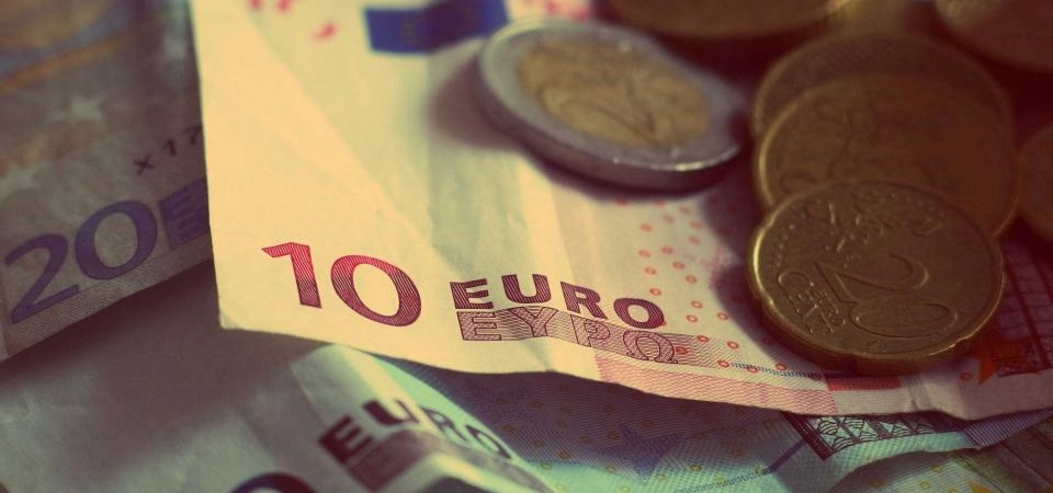 Üst üste duran euro banknotları ve üzerlerindeki madeni paralar