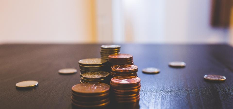 Koyu renkli bir masa üzerinde üst üste dizilmiş madeni para yığınları