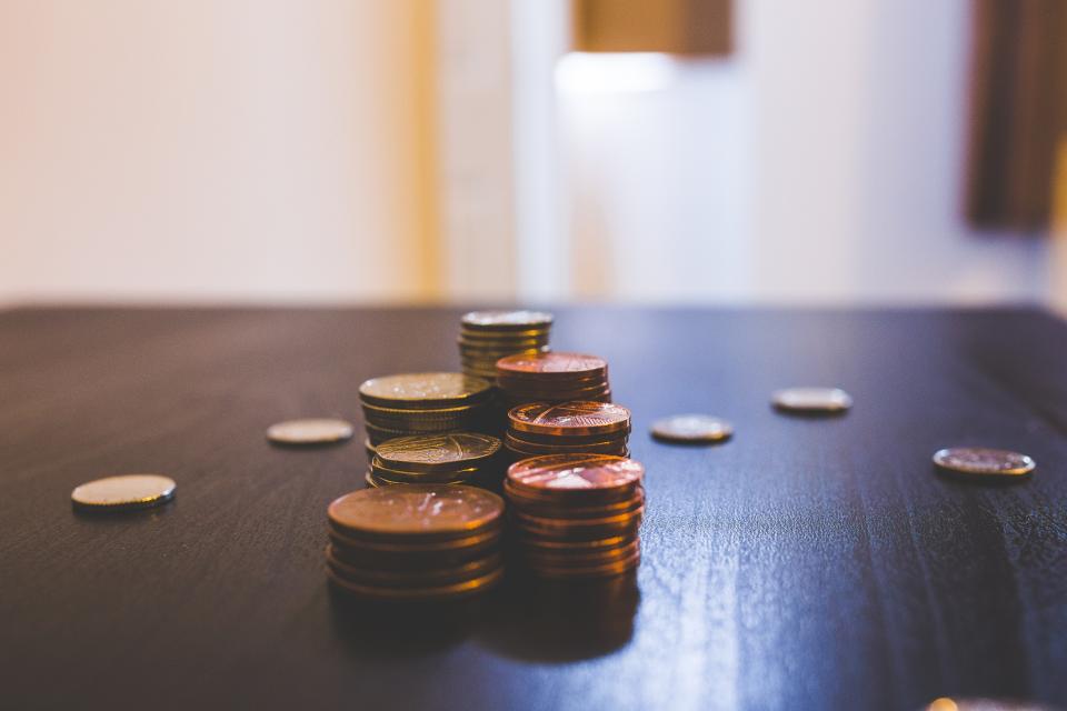 Koyu renkli bir masa üzerinde üst üste dizilmiş madeni para yığınları