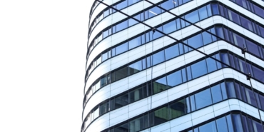 Aşağıdan çekilmiş cam cepheli çok katlı bir ofis binası