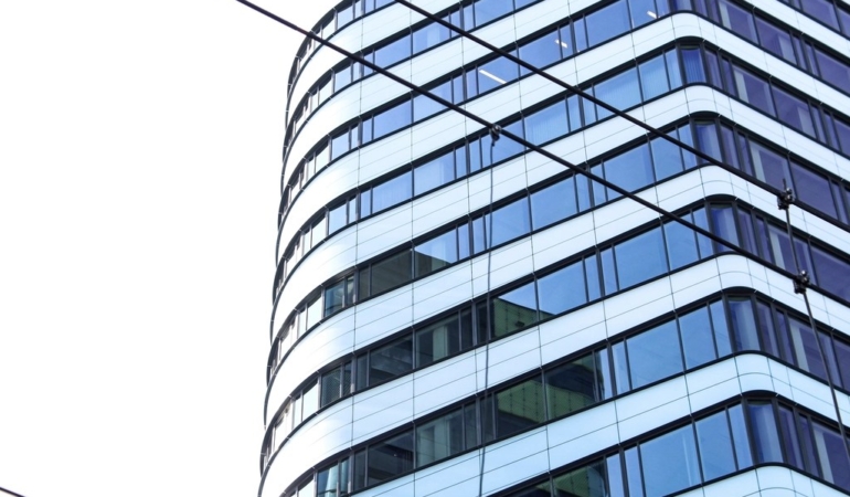 Aşağıdan çekilmiş cam cepheli çok katlı bir ofis binası